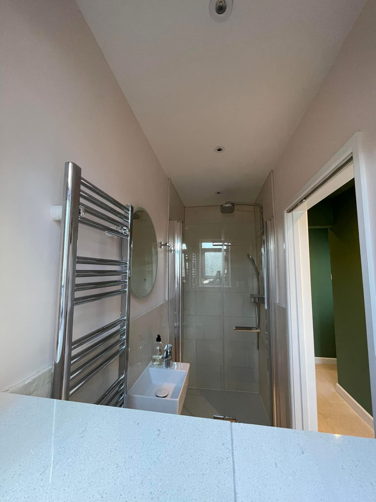 Finished ensuite with soft nude-pink walls, chrome towel rail and glass shower