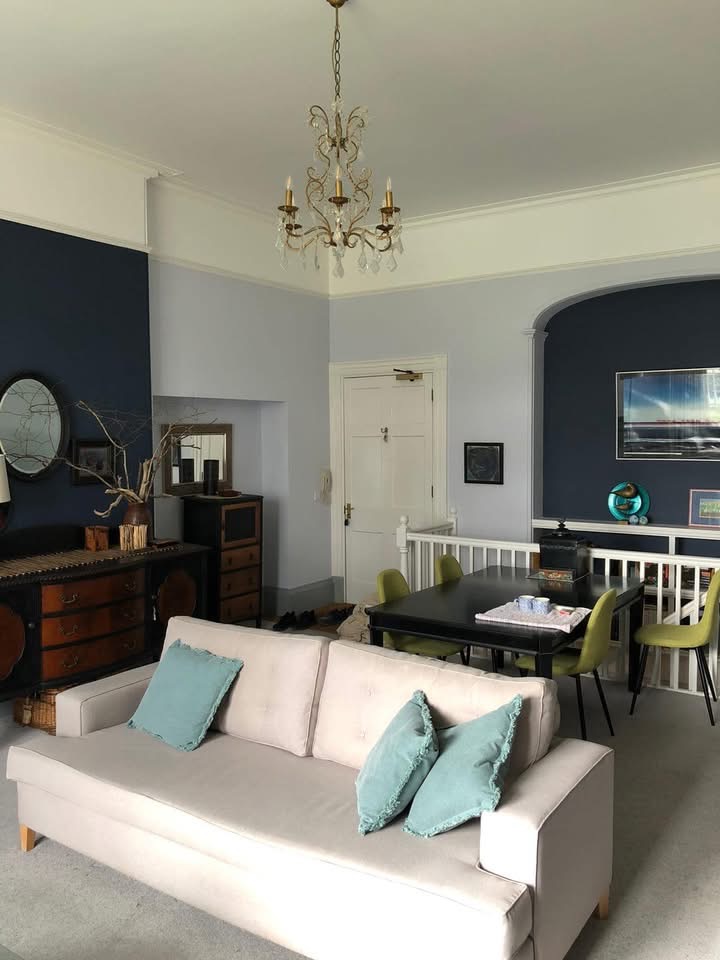 Living room with a deep navy feature wall and pale lilac-grey surrounds