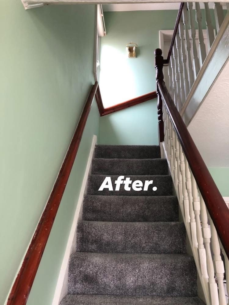Staircase finished in sage green with white balustrades and charcoal carpet