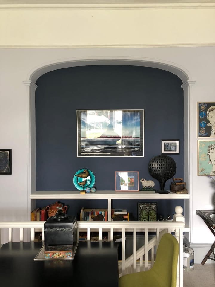 Decorative arched alcove painted deep navy with a sharp clean line against pale grey