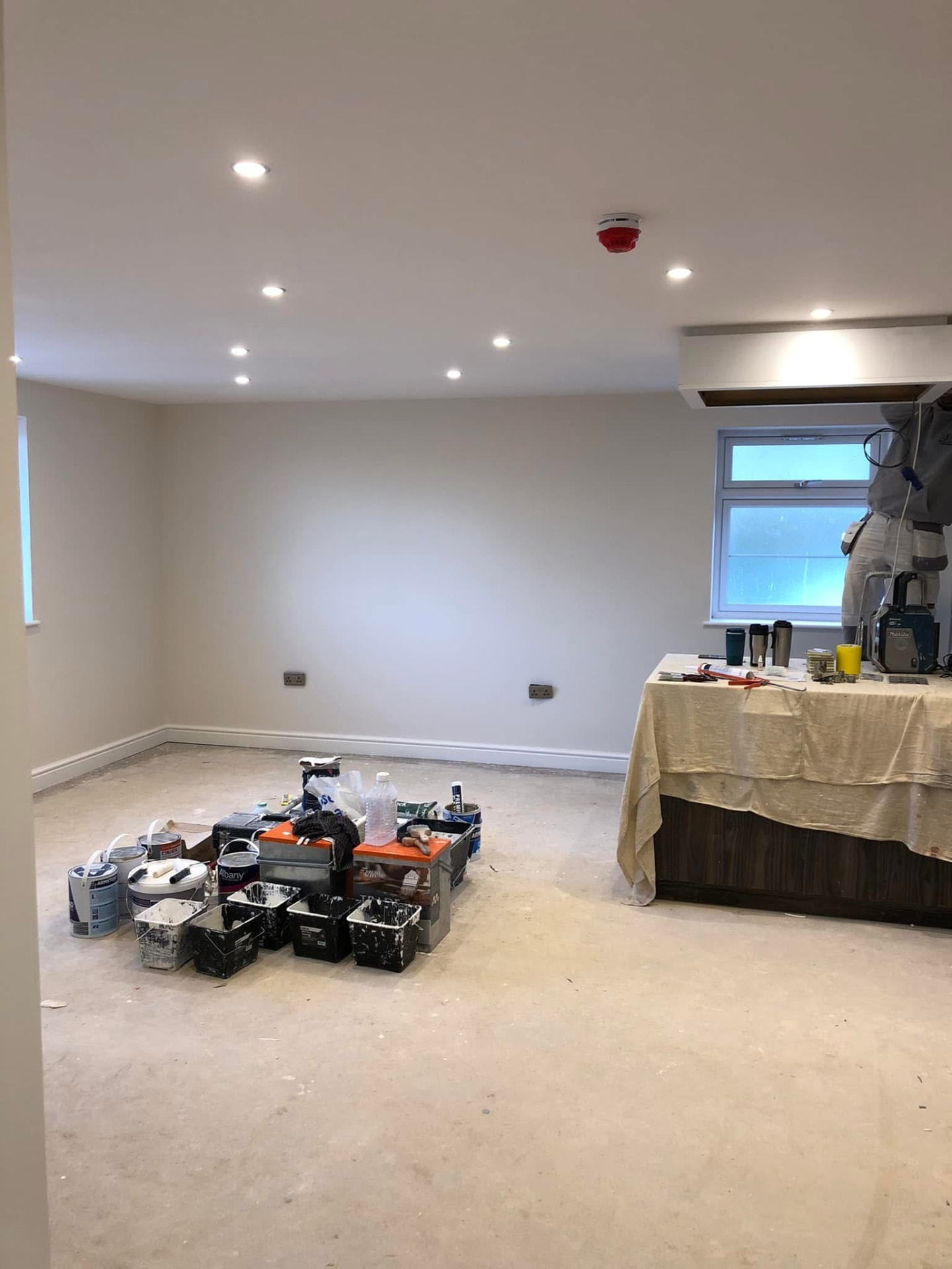 Living room finished in a soft uniform cream with recessed spotlights installed
