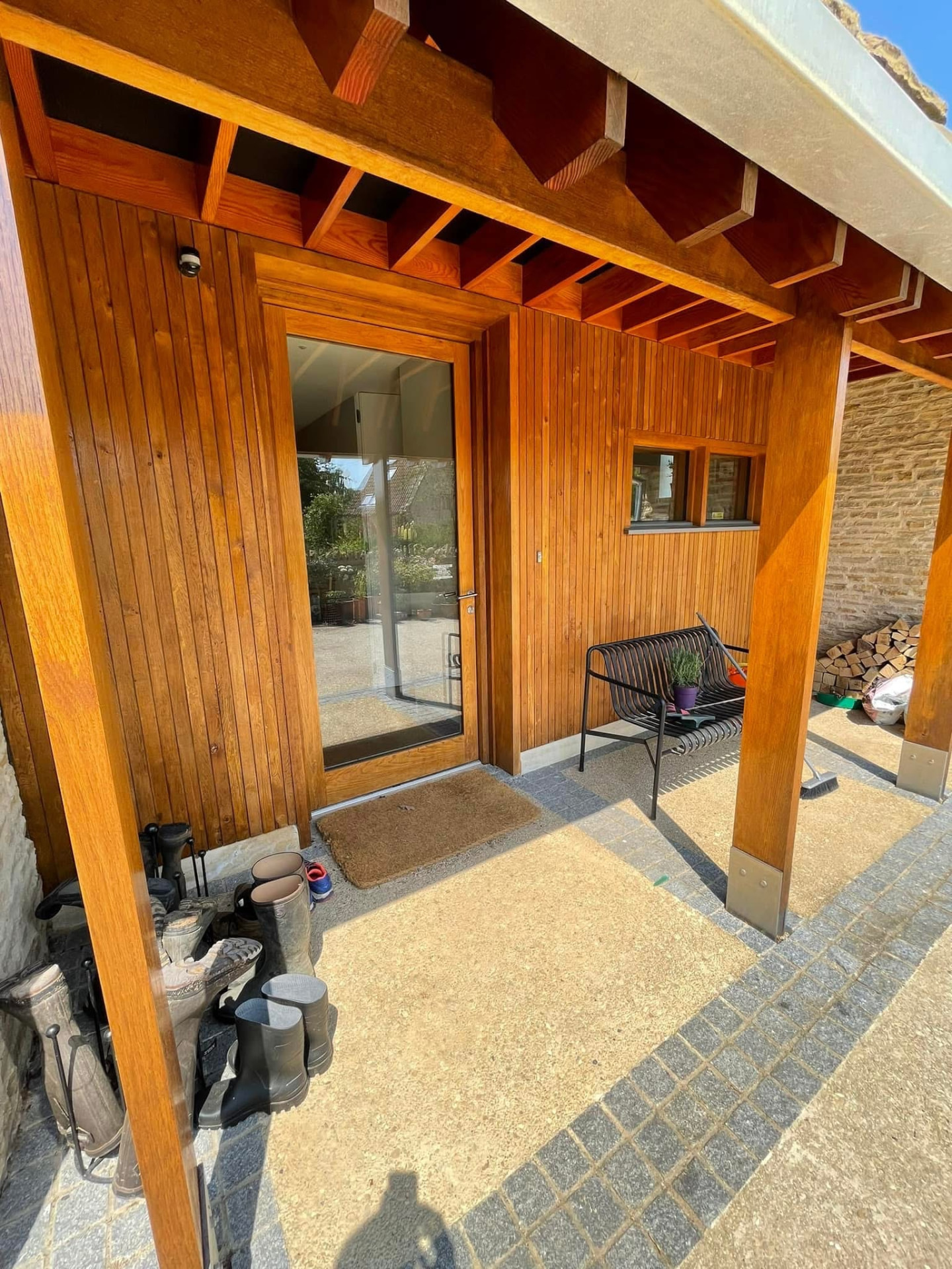 Entrance porch with honey-stained vertical cladding and a glass-panelled door