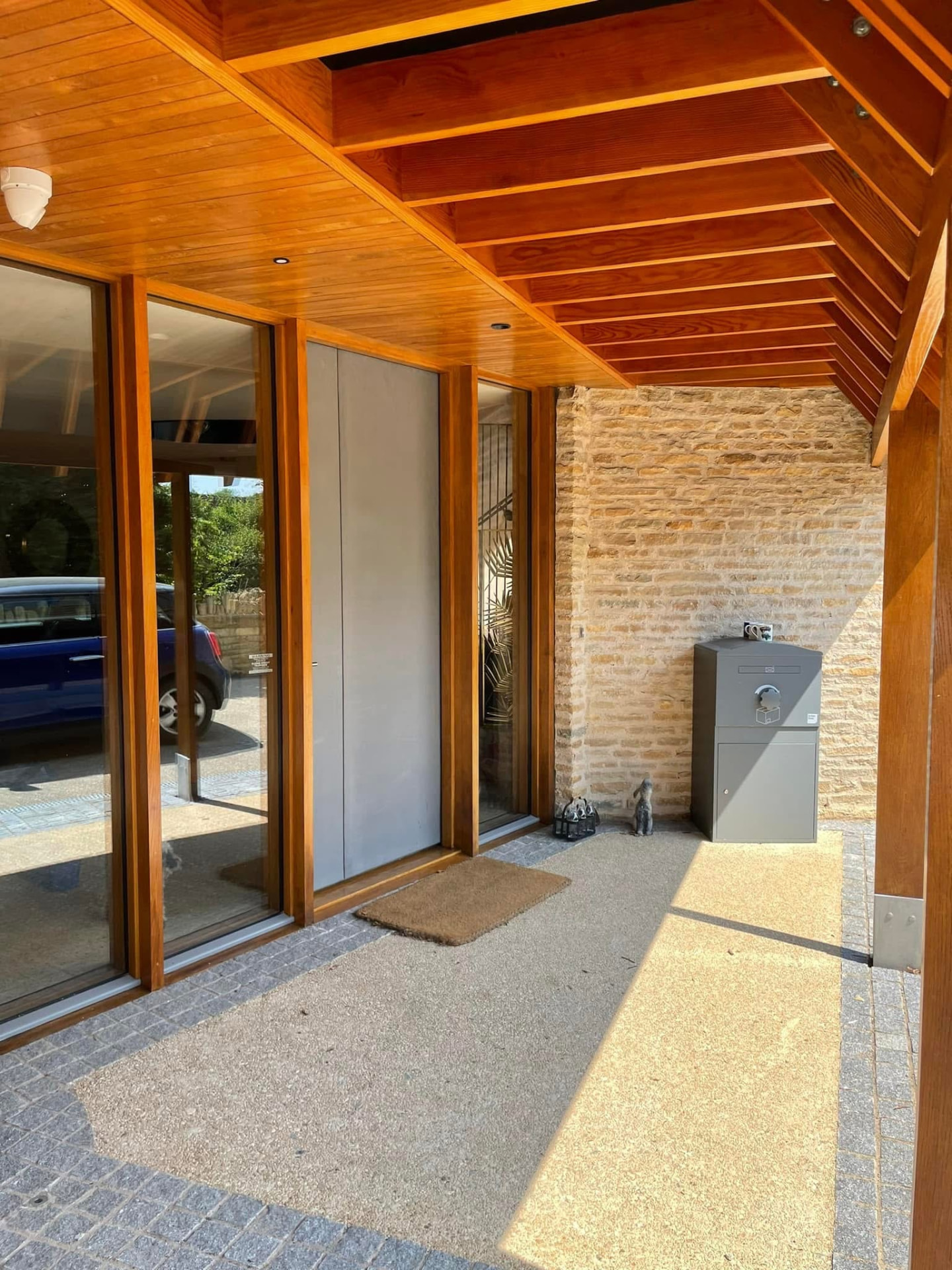 Completed timber-framed front entrance with a warm natural finish